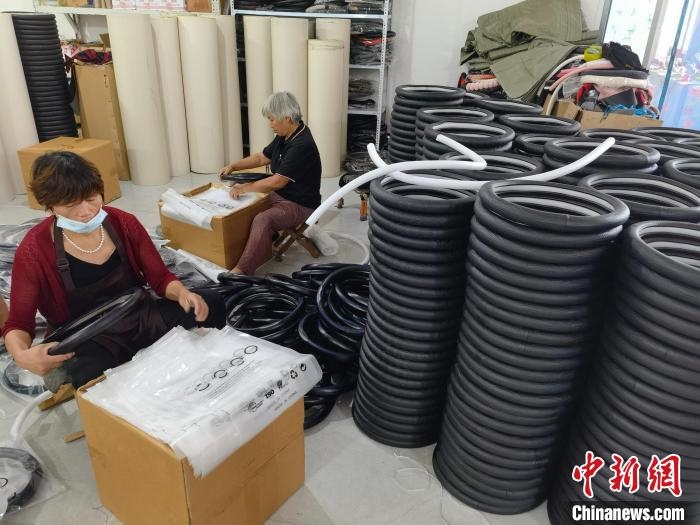 圖為村民在汽車飾品企業(yè)生產(chǎn)車間中工作。　呂子豪 攝