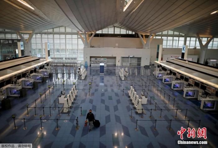 資料圖：日本東京，東京國(guó)際機(jī)場(chǎng)，一名乘客在國(guó)際航班航站樓的登機(jī)區(qū)。