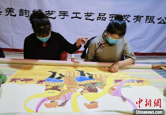 圖為皮繡藝人在市集上“秀”指尖技藝?！●R銘言 攝