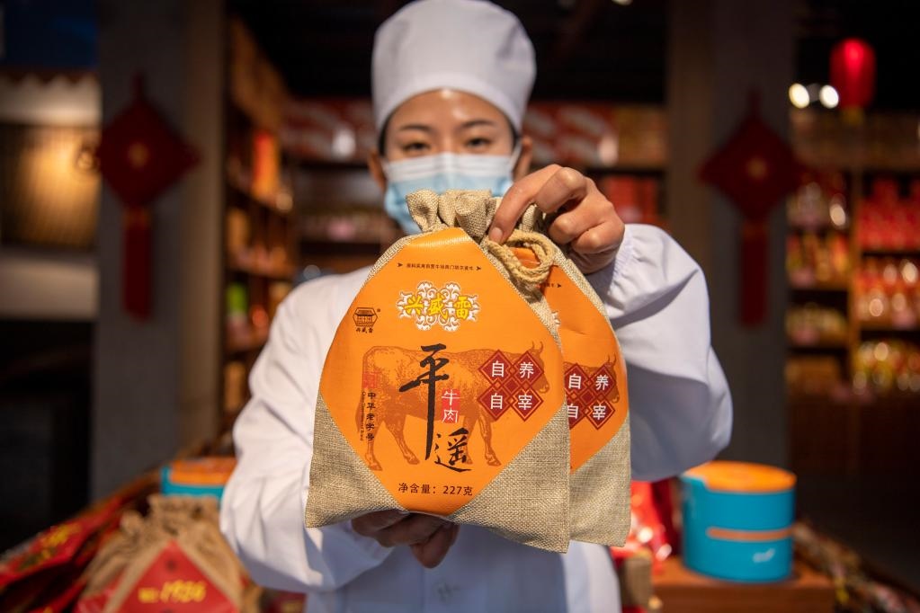 1月27日，在平遙古城南大街的一家平遙牛肉店內(nèi)，工作人員展示一款牛肉產(chǎn)品。新華社記者 楊晨光 攝