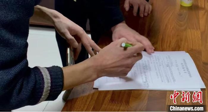 圖為現(xiàn)場下達詢問通知書。　李婷婷 攝