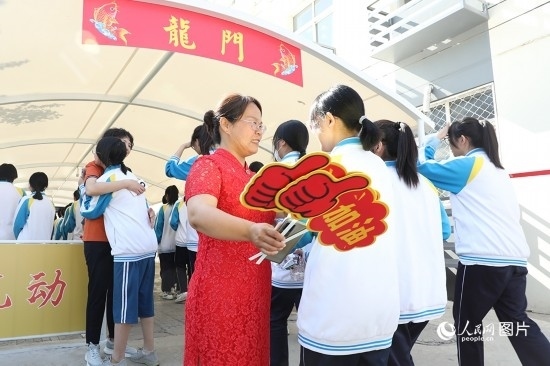 6月7日一早，雄安新區(qū)安新中學(xué)老師在給同學(xué)們加油鼓勁兒。人民網(wǎng) 李兆民攝