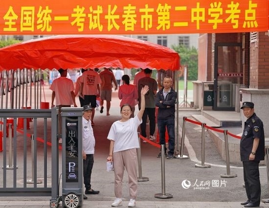 6月7日，在長春市第二中學(xué)考點，一名考生信心滿滿進(jìn)入考場，并與家長揮手致意。人民網(wǎng)記者 李洋攝