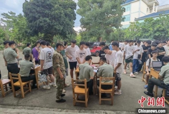 專武干部在發(fā)放兵役登記證。韋碩 攝