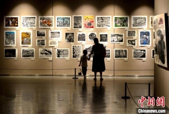 圖為家長(zhǎng)帶著孩子參觀展覽。呂明 攝