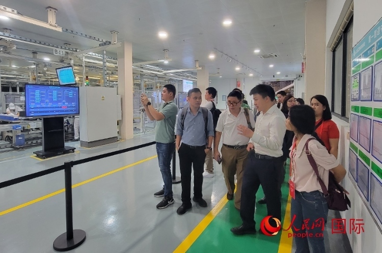 廣汽埃安工作人員向外媒記者進行介紹。人民網(wǎng) 寧玉瑛攝