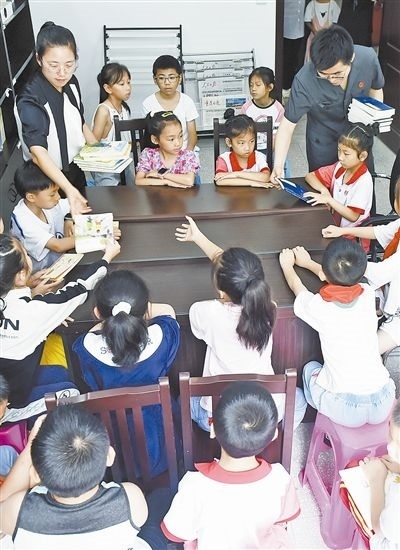  圖④：法院干警為留守兒童發(fā)放暑假讀物。