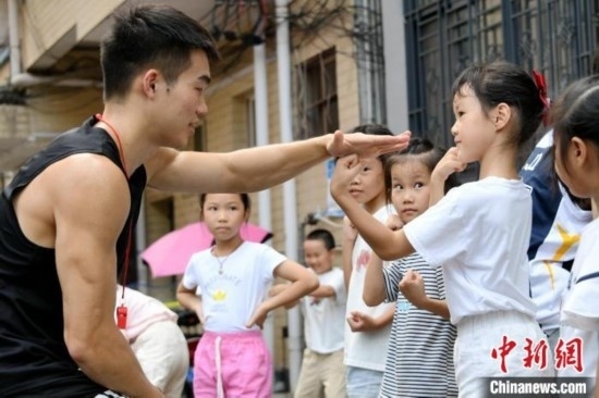 圖為大學(xué)生志愿者在組織孩子們參加體育健身活動(dòng)。廖光福 攝