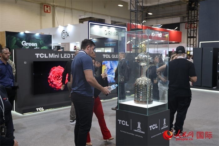 參觀者在TCL展臺前觀看南美解放者杯獎杯，據(jù)介紹，TCL是南美解放者杯（2023—2026賽季）全球官方合作伙伴。（人民網(wǎng)記者 時元皓攝）