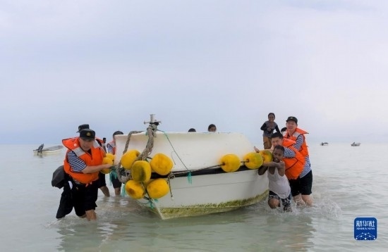 7月21日，中國海軍“和平方舟”號醫(yī)院船醫(yī)護(hù)人員涉水登島，前往基里巴斯一診療點(diǎn)。新華社記者 黎云 攝