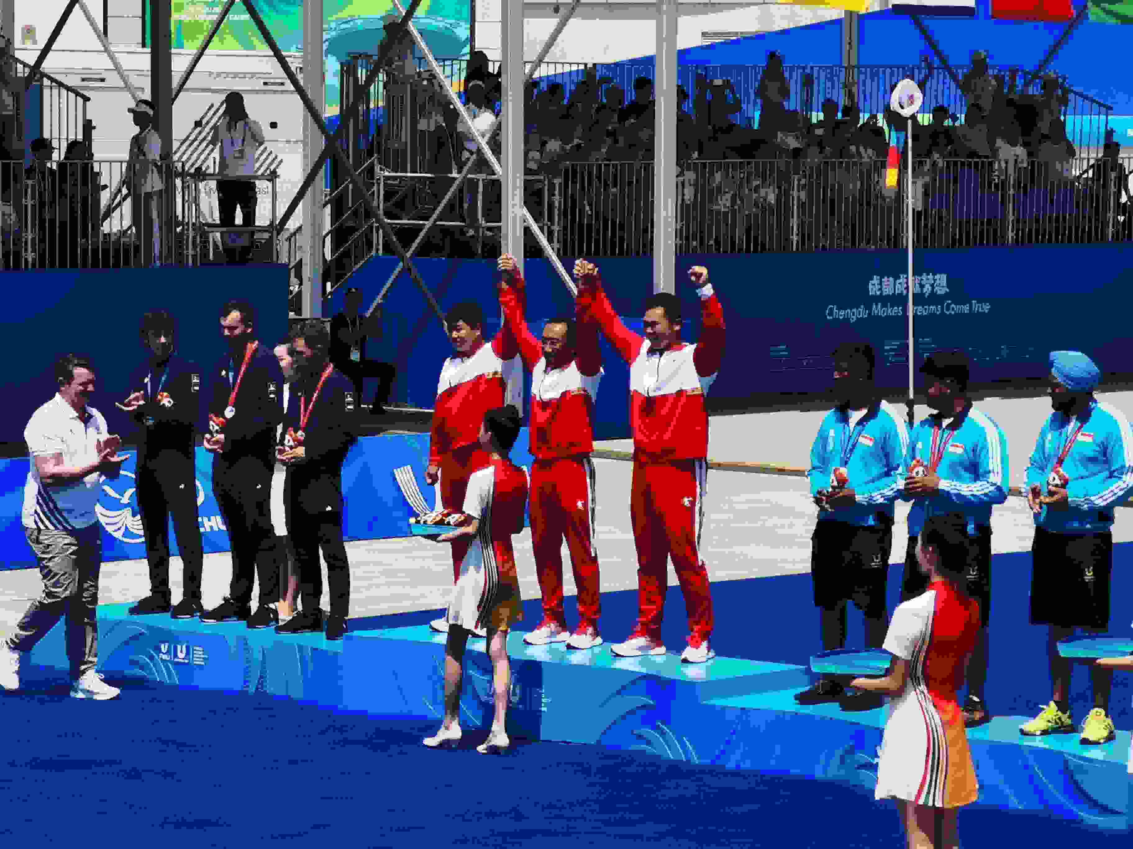 7月30日，在成都大運會男子復合弓團體頒獎儀式中，中國隊慶祝奪得冠軍。 人民網(wǎng)記者 楊磊攝