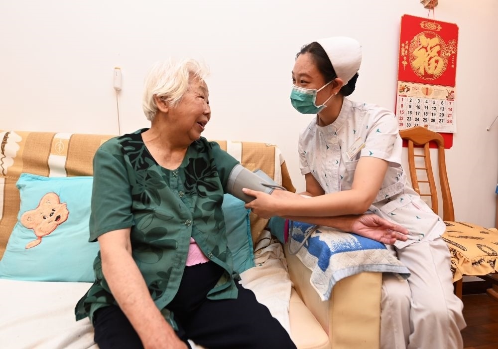 河北廊坊三河市燕達金色年華健康養(yǎng)護中心醫(yī)務(wù)人員為入住老人測量血壓（2023年7月20日攝）。新華社記者 朱旭東 攝