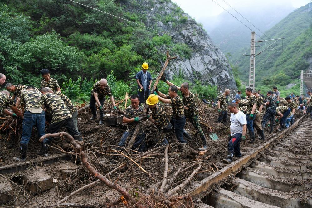 8月1日，在北京市門頭溝區(qū)水峪嘴村附近一段被阻斷的鐵路線上，中鐵六局工作人員在清理軌道上的雜物，全力恢復(fù)交通。新華社記者 鞠煥宗 攝