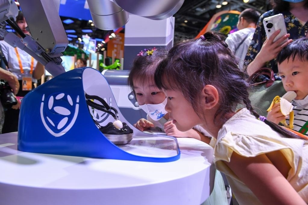 9月3日，幾名小朋友在國(guó)家會(huì)議中心觀看單孔腔鏡手術(shù)機(jī)器人展示。新華社記者 鞠煥宗 攝