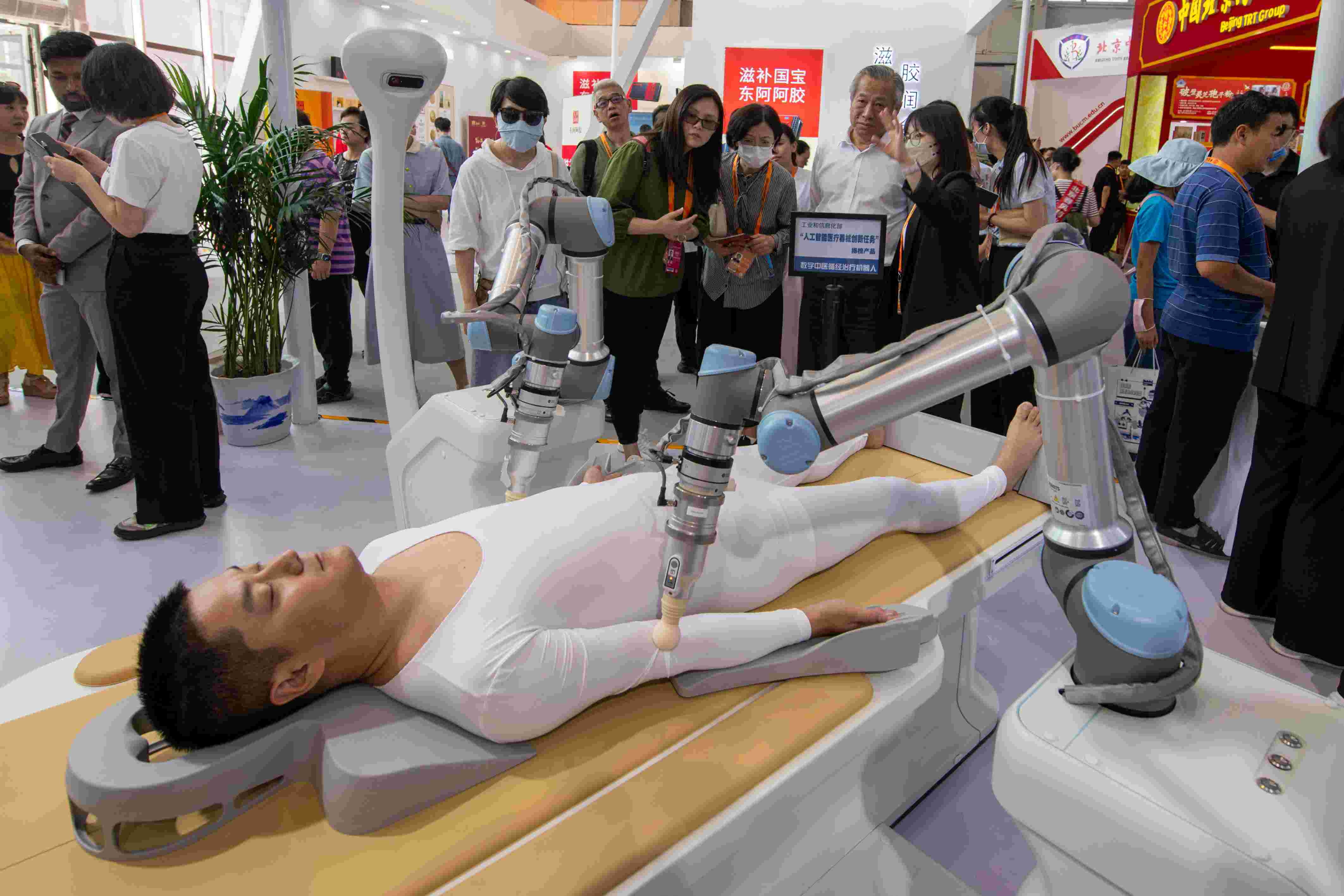 在位于首鋼園的健康衛(wèi)生服務(wù)展區(qū)，觀眾正在參觀數(shù)字中醫(yī)循經(jīng)治療機器人。人民網(wǎng)記者 翁奇羽攝