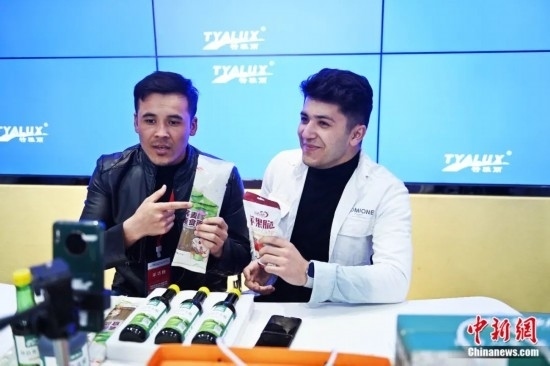 2023年3月，甘肅省慶陽市環(huán)縣電商創(chuàng)業(yè)孵化基地內(nèi)，來自蘭州文理學院的塔吉克斯坦留學生正在協(xié)助主播直播帶貨當?shù)剞r(nóng)特產(chǎn)品。李亞龍 攝