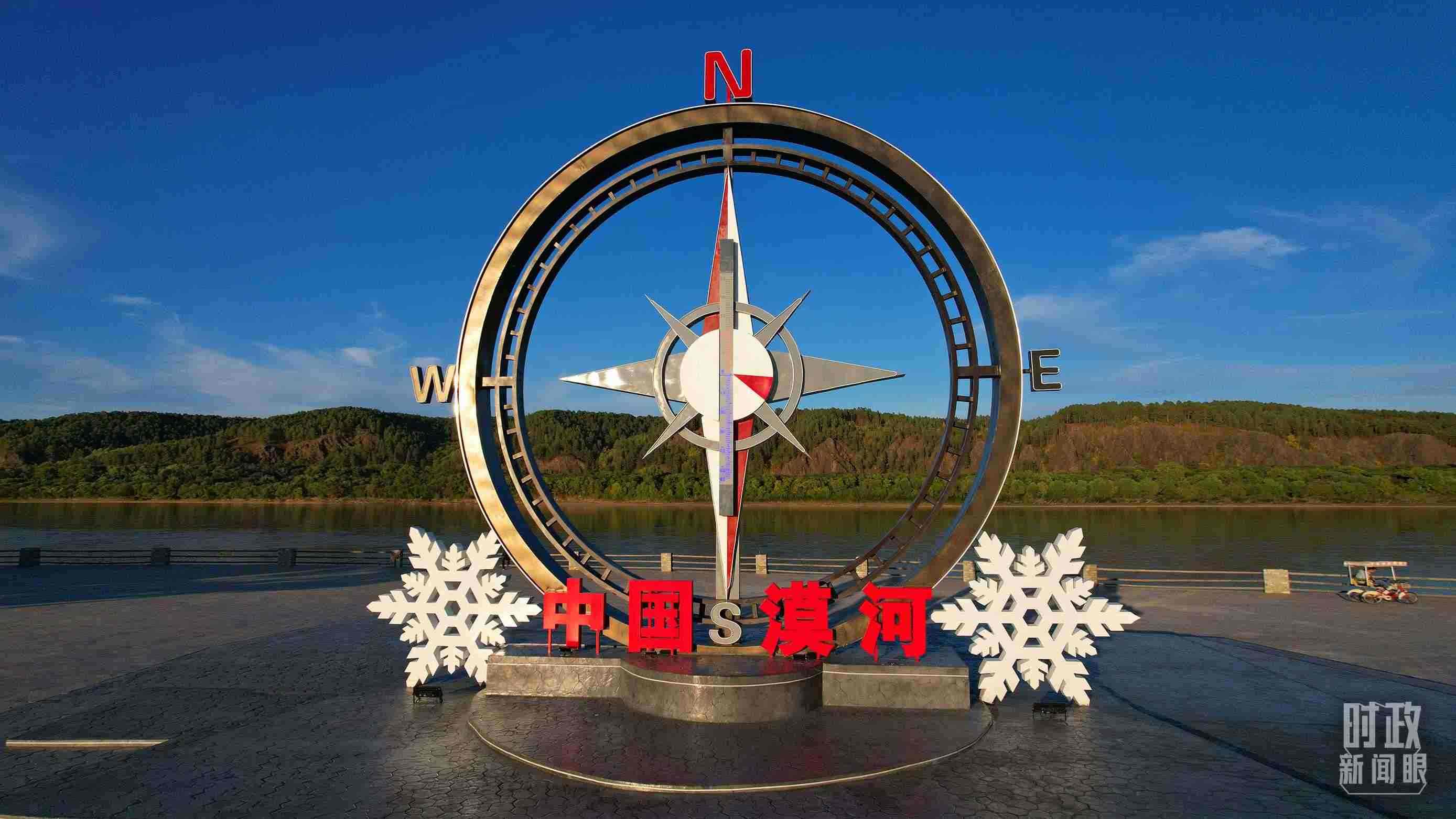 △指北針雕塑是北極村標志性建筑之一，其紅色指針指向正北方。上面的大型溫度計高12.22米，象征北極村位于東經(jīng)122°20′。（總臺央視記者范凱拍攝）