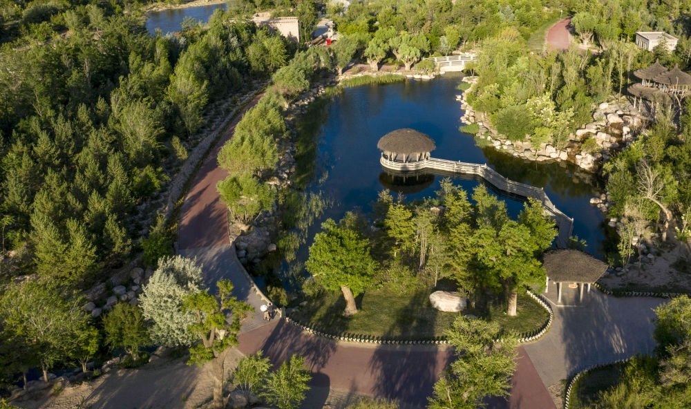 坐落在寧夏銀川市賀蘭山腳下的賀蘭山運(yùn)動(dòng)休閑公園（2021年5月27日攝，無(wú)人機(jī)照片）。這里曾是一片砂石采礦塌陷區(qū)，當(dāng)?shù)赝ㄟ^(guò)植被景觀再造、水系建設(shè)、現(xiàn)代管網(wǎng)鋪建等手段，重新利用廢石、廢坑及各類廢棄建筑材料，把這里變成一座免費(fèi)開(kāi)放的主題公園。新華社記者 馮開(kāi)華 攝