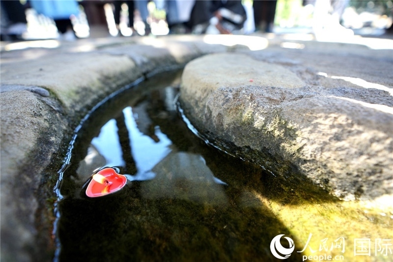 圖為水渠里流過的“桃心”蠟燭。人民網 盧鵬宇攝