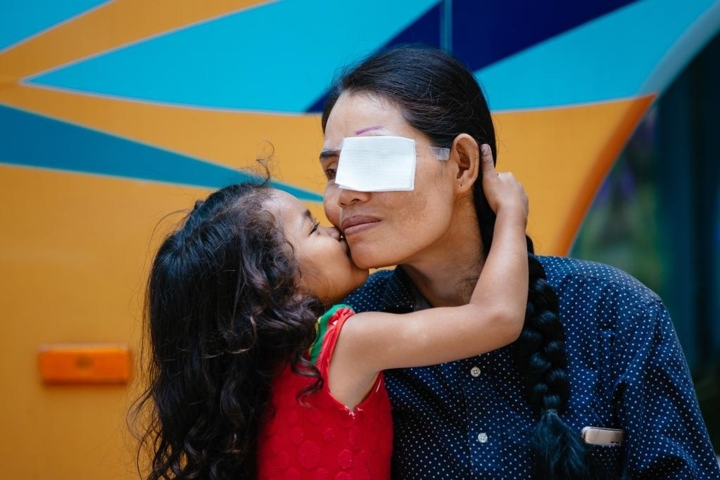 2019年3月15日，在柬埔寨磅湛省醫(yī)院，即將接受白內(nèi)障手術(shù)的患者孫美樂接受女兒的親吻祝福。在接受了中國醫(yī)療隊(duì)的白內(nèi)障義診手術(shù)后，她的視力逐步恢復(fù)，生活有了新的光明和希望。