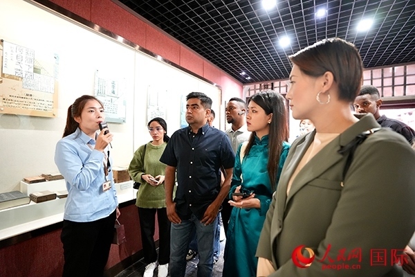 選手們認(rèn)真聆聽導(dǎo)游講解。人民網(wǎng) 盧鵬宇攝