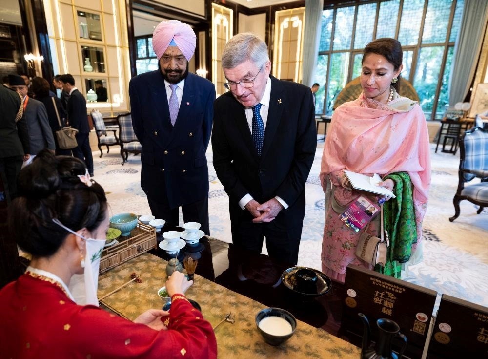 △歡迎宴會前，亞奧理事會代理主席辛格和夫人維尼塔、國際奧委會主席巴赫欣賞非遺展示。