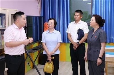 圖③：“小公民法律課堂”開講前，全國人大代表殷其龍（右二）、重慶市人大代表李自玲（左二）聽取楊家坪中學負責人關于未成年人思想教育工作情況的介紹。