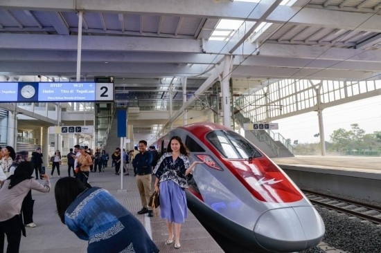  10月17日，在印度尼西亞萬隆德卡魯爾站，乘客在站臺上和雅萬高鐵高速動車組列車合影。新華社記者 徐欽 攝