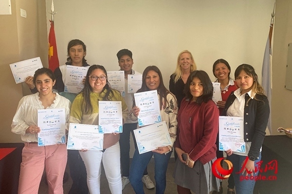 社區(qū)工作專家莫伊拉（后排右二）向“中文工坊”第二期培訓(xùn)班部分結(jié)業(yè)學(xué)員頒發(fā)由薩爾塔省教育部簽發(fā)的結(jié)業(yè)證書。人民網(wǎng)記者 吳思萱攝