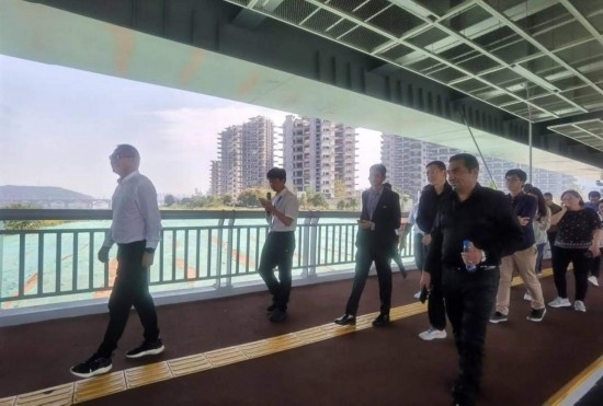 10月24日，2023“一帶一路”媒體合作論壇聯(lián)合采訪團(tuán)團(tuán)員走在清水塘大橋景觀通道上。本報(bào)記者 常雯宜攝