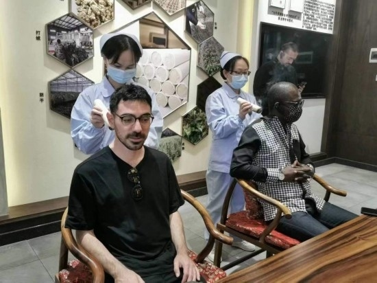 2023“一帶一路”媒體合作論壇聯(lián)合采訪團團員在九牛草展示館體驗艾灸。（本報記者 黃超攝）