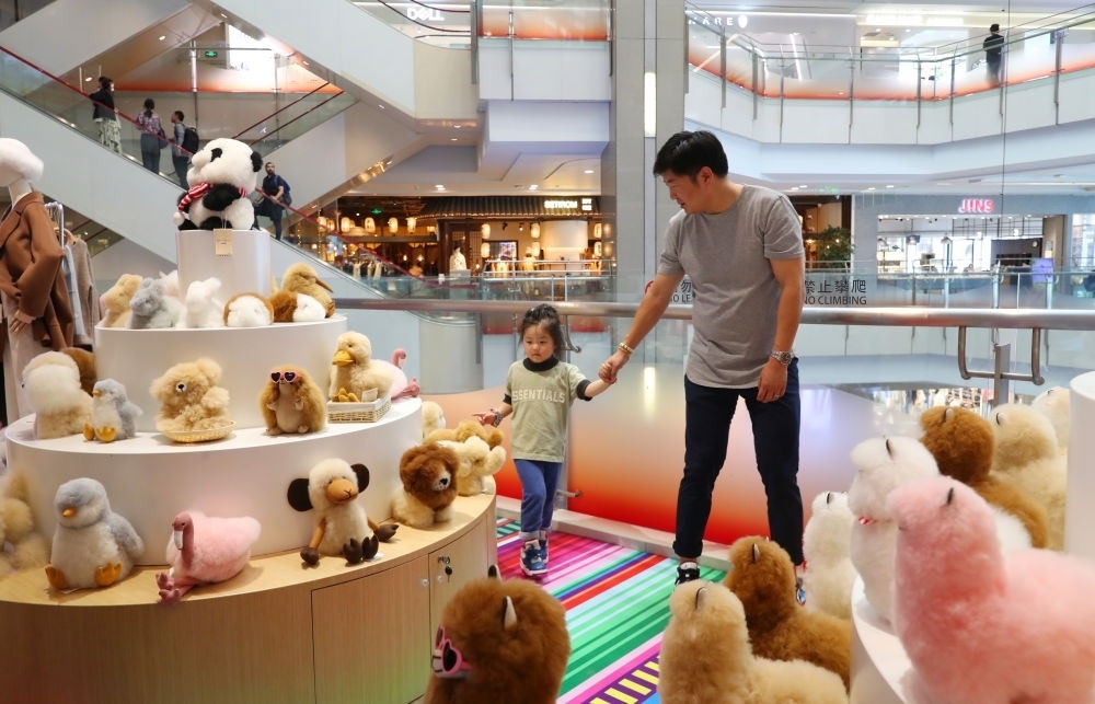 2023年11月2日，顧客在溫暖駝品牌專柜內(nèi)選購。連續(xù)六年參加進(jìn)博會的秘魯羊駝制品品牌溫暖駝在上海市中心商場開設(shè)了專柜。新華社記者 方喆 攝