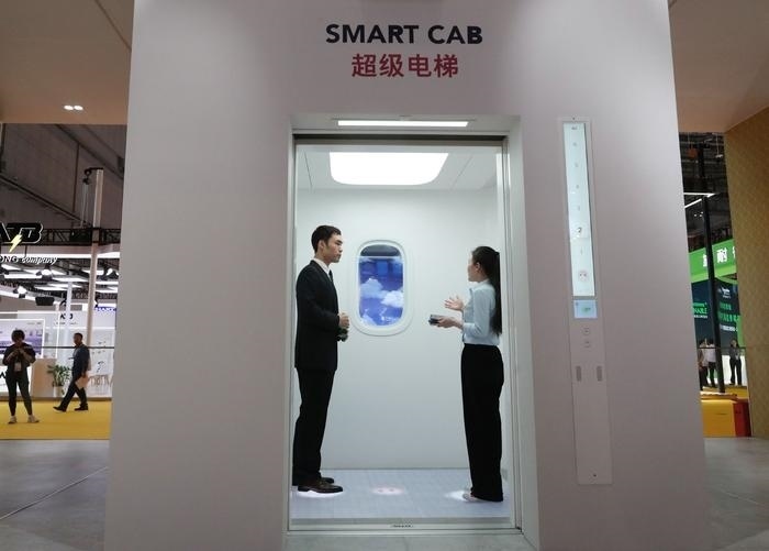 11月5日，工作人員（右）在第六屆進(jìn)博會(huì)上向參觀者介紹奧的斯公司全新推出的超級(jí)電梯。