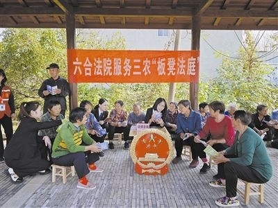  圖③：干警向附近農(nóng)戶解讀相關(guān)法律法規(guī)。