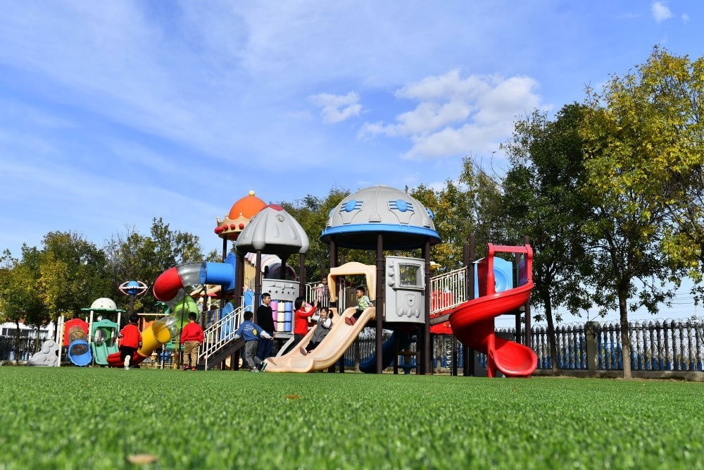 在山東省東營市墾利區(qū)楊廟社區(qū)幼兒園，孩子們在老師的帶領下進行戶外活動（2021年10月19日攝）。新華社記者 郭緒雷 攝