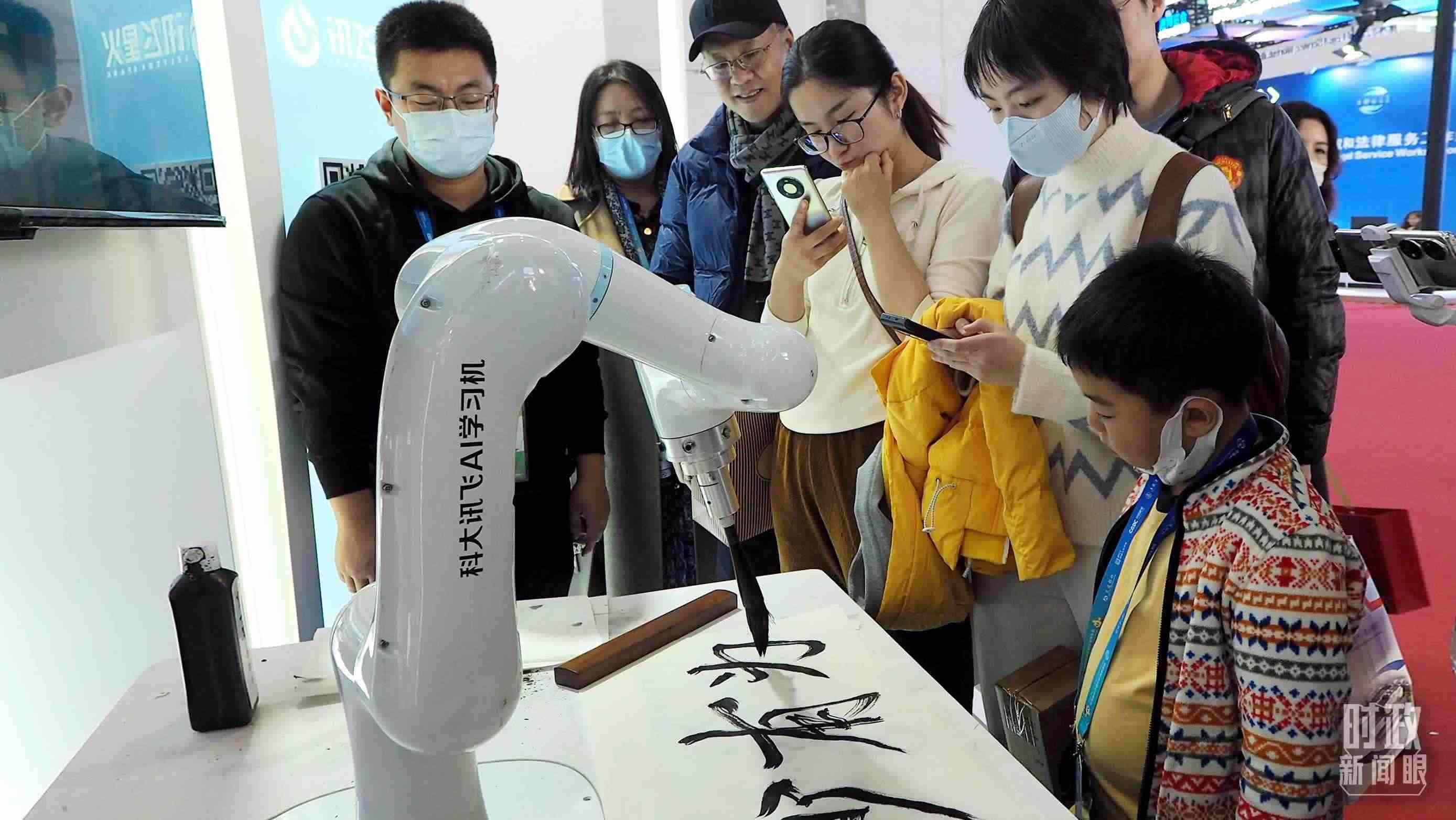 △觀眾在首屆鏈博會(huì)上體驗(yàn)AI書法機(jī)器人。