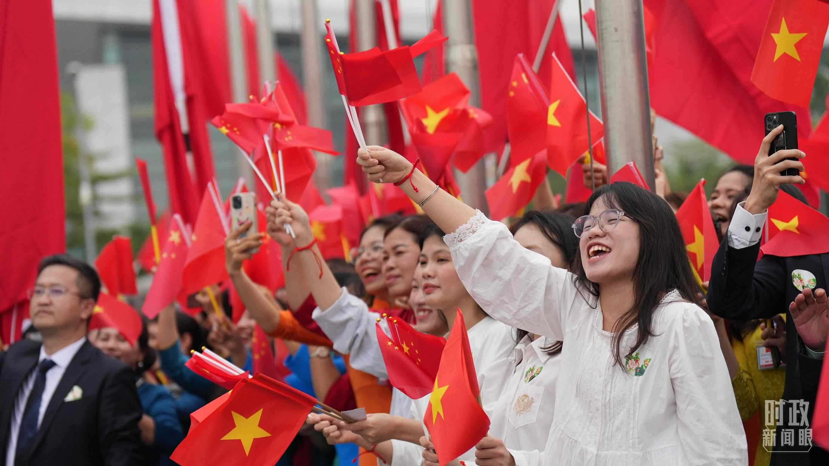 △人們揮舞兩國旗幟歡迎習(xí)近平訪越。（總臺國廣記者李晉拍攝）