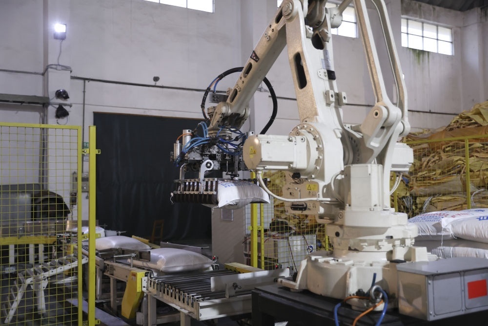 12月14日，在廣西來(lái)賓東糖鳳凰有限公司，機(jī)械臂在廠房碼放白砂糖成品。