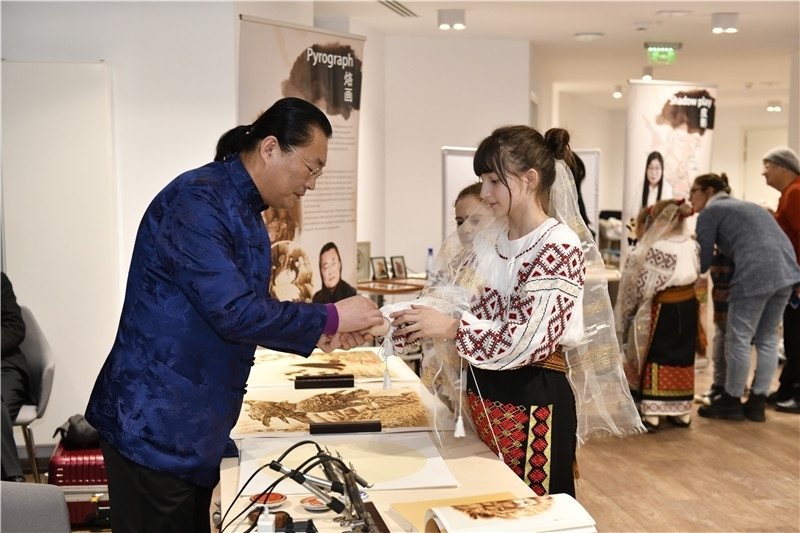 圖為羅馬尼亞小學(xué)生在現(xiàn)場體驗(yàn)烙畫。 布加勒斯特中國文化中心供圖