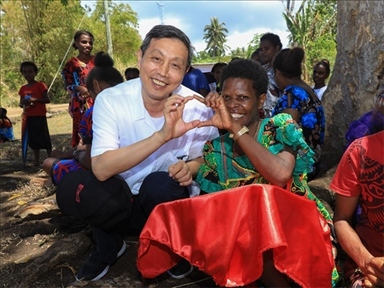 2023年12月18日，中國駐瓦努阿圖大使李名剛和前來觀看瓦努阿圖公路項目二期馬勒庫拉段移交儀式的當(dāng)?shù)鼐用窈嫌?。人民網(wǎng) 賀吉攝