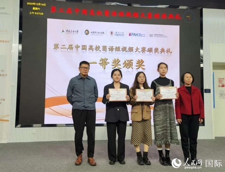 澳門大學中葡雙語教學暨培訓中心主任姚京明（左一）和中國傳媒大學外國語言文化學院院長文春英（右一）為一等獎獲得者頒獎。人民網(wǎng)記者 魯揚攝