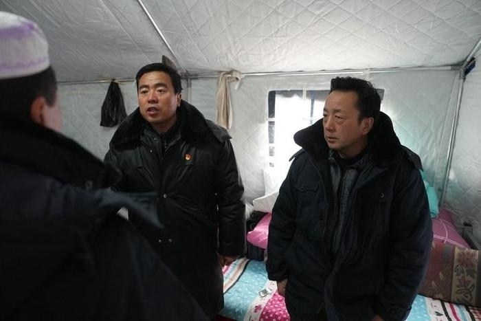 2023年12月22日，積石山縣大河家鎮(zhèn)大河村黨支部書記馬成忠（右二）在帳篷里和受災(zāi)群眾交流。新華社記者 陳斌 攝