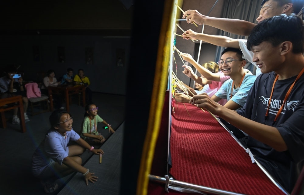 2023年8月8日，進行暑期研學的學生在位于陜西省西安市的中國秦腔藝術博物館體驗皮影戲演出。新華社記者 鄒競一 攝