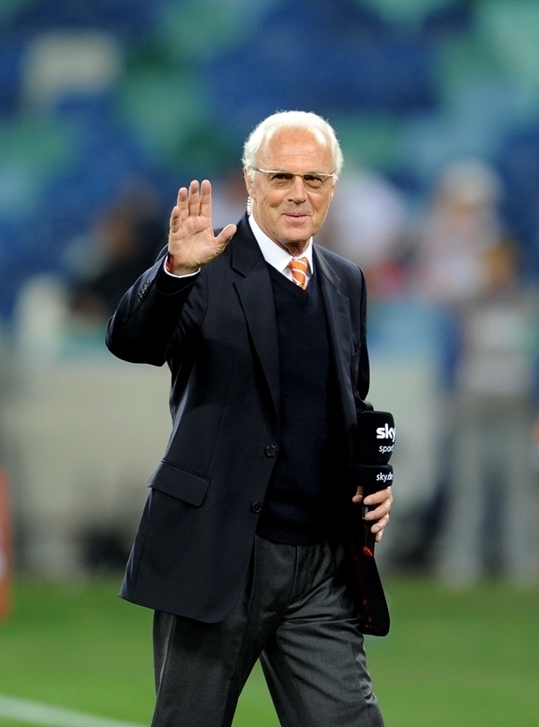 這是2010年7月7日，在南非德班舉行的2010年足球世界杯德國(guó)隊(duì)對(duì)陣西班牙隊(duì)的半決賽前，貝肯鮑爾接受電視臺(tái)采訪時(shí)和友人打招呼。新華社記者 王毓國(guó) 攝