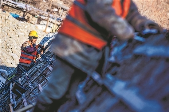 1月3日，房山區(qū)，工人正在雙泉河修筑堤壩。