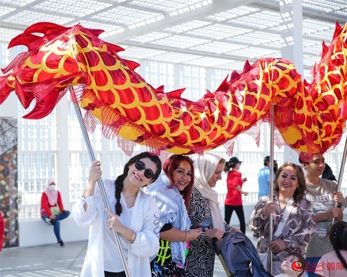 游客體驗舞龍。 人民網(wǎng) 塔里克·易卜拉欣攝