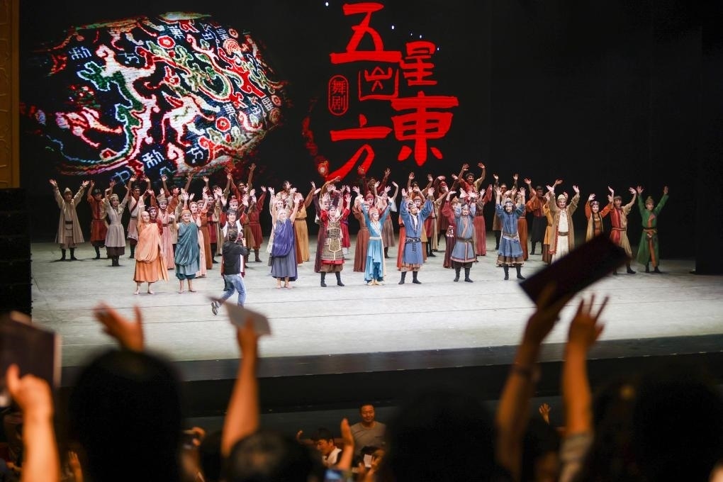 2023年7月31日，新疆和田地區(qū)新玉歌舞團在烏魯木齊京劇院演出舞劇《五星出東方》后和觀眾互相揮手致意。這場演出是第六屆中國新疆國際民族舞蹈節(jié)的參演劇目之一，曾榮獲國家“文華獎”等。新華社記者 郝昭 攝