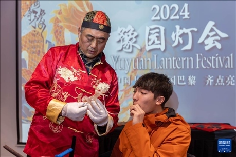 1月28日，在上海豫園舉行的民俗活動(dòng)上，美國馬斯卡廷中學(xué)學(xué)生在非遺傳承人的指導(dǎo)下吹糖偶。 新華社記者 王翔 攝