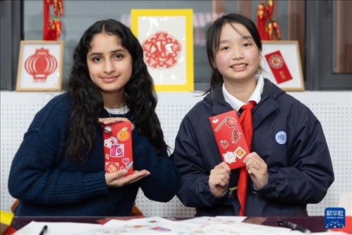 1月28日，美國馬斯卡廷中學(xué)學(xué)生（左）和復(fù)旦大學(xué)第二附屬學(xué)校學(xué)生展示互相送出的寫有寄語祝福的紅包。 新華社記者 王翔 攝