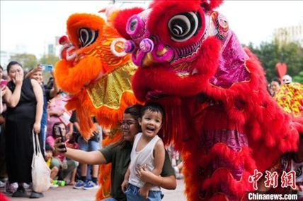 圖為舞獅表演吸引民眾合影。張興龍攝